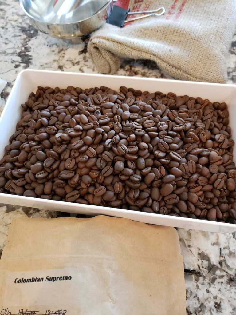 Fresh roasted beans resting in a container before packaging.